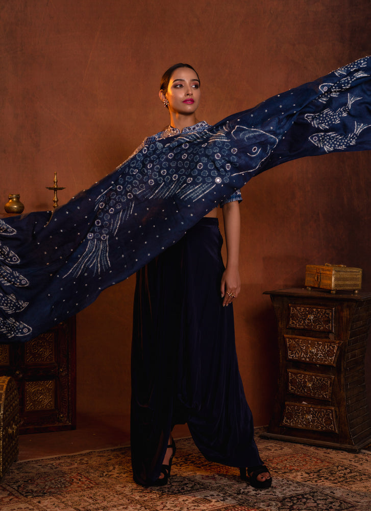 
                  
                    Dhoti draped skirt styled with shibori hand worked blouse and hand dyed fishes in bandhani dupatta
                  
                